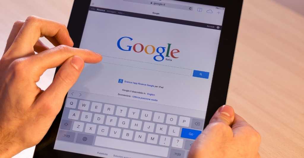 Person scrolling on an iPad with Google showing.