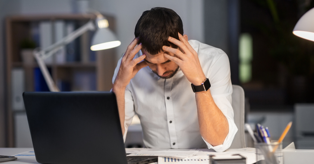 frusted individual next to laptop