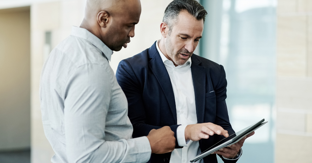 man showing another man his ipad